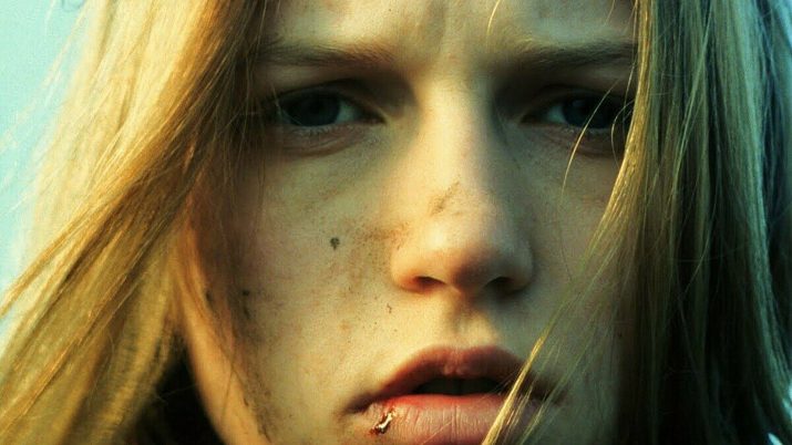 Frau mit langen blonden Haaren, die nach links blickt, vor hellem Hintergrund