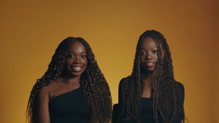 Zwei Protagonistinnen des Films NOCH LANGE KEINE LIPIZZANER vor einem orangen Hintergrund.