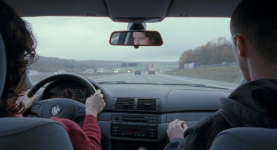 Blick von der Rückbank eines Autos auf die Fahrerin und den Beifahrer