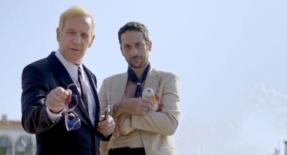 Zwei Männer im Anzug schauen Richtung Kamera.