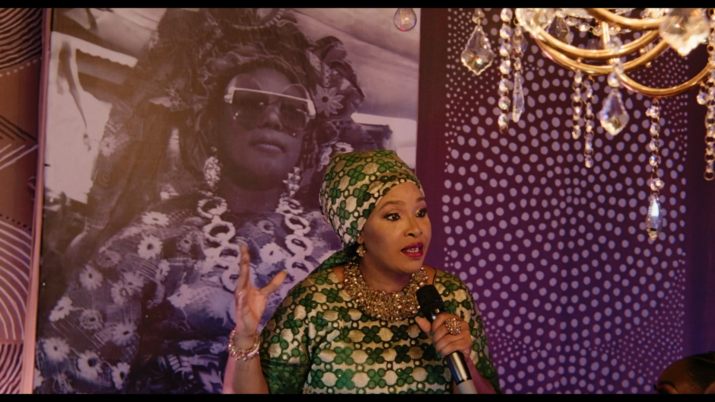 Still aus dem Film STOFF. Eine Frau hält ein Mikrofon.