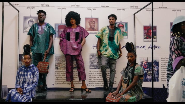 Still aus dem Film STOFF. Fünf Personen präsentieren bunte Kleidung.