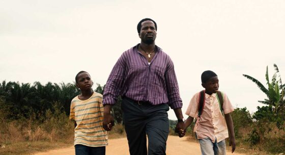 Ein Mann geht mit zwei Buben an den Händen entschlossen Richtung Kamera.