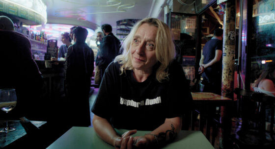 Eine Frau mit schwarzem Shirt sitzt in einer Bar