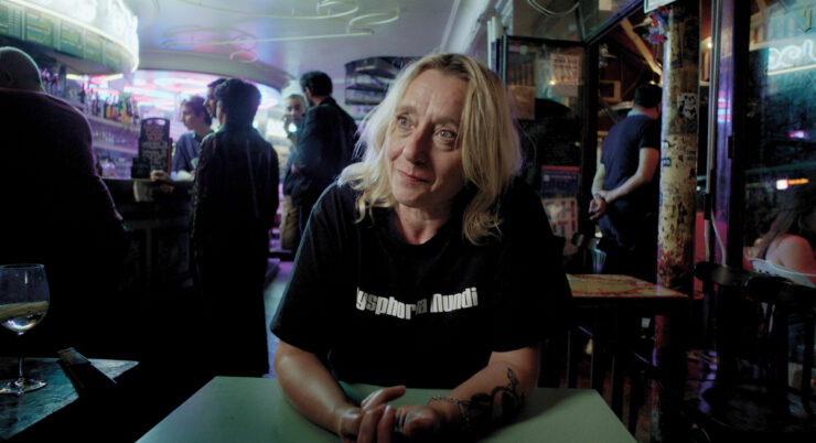 Eine Frau mit schwarzem Shirt sitzt in einer Bar