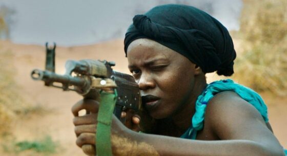 Person mit Turban hält ein Gewehr im Anschlag