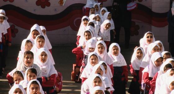 Mädchen mit weißem Kopftuch stehen hintereinander