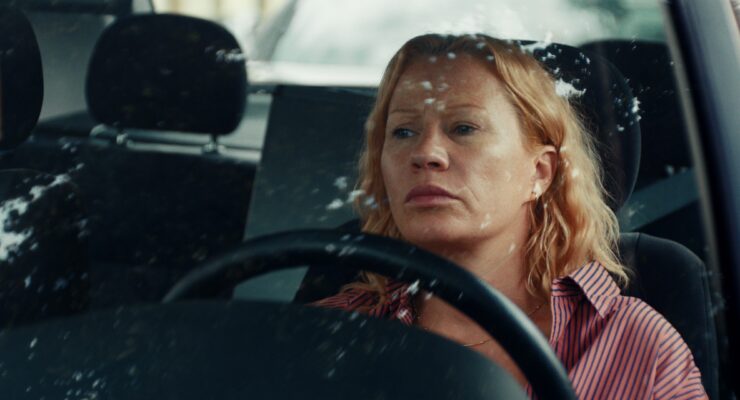 Birgit Minichmayr sitz im Auto hinter dem Lenkrad.