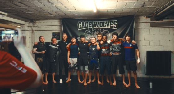 Einige junge Männer stehen als Gruppe vor dem Banner 'Cage Wolves'